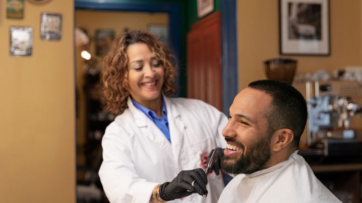 Ung man får skägget fixat hos en barberare i Victoria
